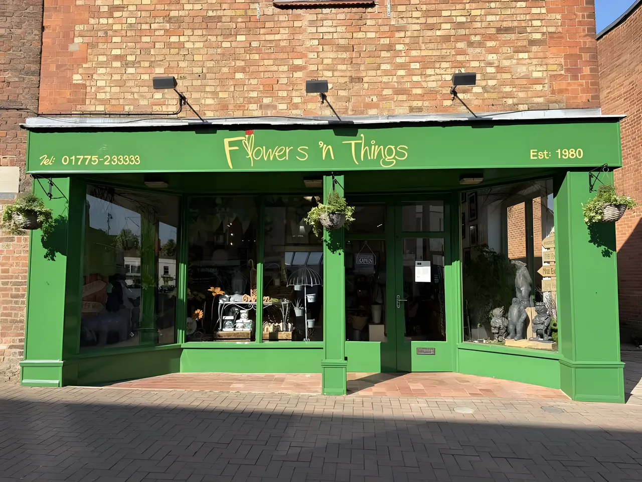 Shop front repainted in green, with the work fitted around opening hours